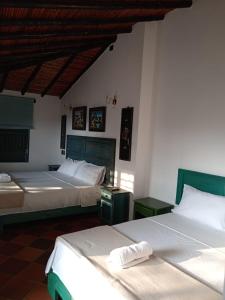 2 camas en una habitación con 2 camas sidx sidx sidx en Casa Silva - Hotel Cafe en Curití