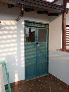 uma porta azul num quarto com piso em azulejo em Casa Silva - Hotel Cafe em Curití