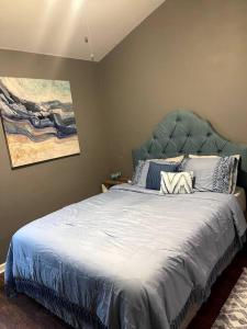 Bett mit blauem Kopfteil in einem Schlafzimmer in der Unterkunft Chic Retreat in Byron