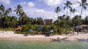 een resort op het strand met palmbomen bij Flat Beira Mar Carneiros in Tamandaré