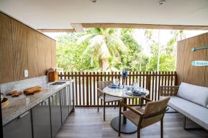 a kitchen and living room with a table and chairs at Flat Beira Mar Carneiros in Tamandaré