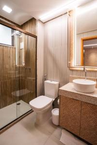 een badkamer met een toilet, een wastafel en een douche bij Flat Beira Mar Carneiros in Tamandaré