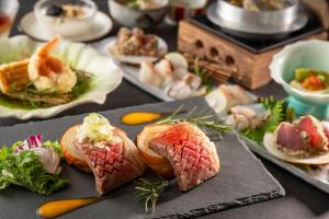 una mesa cubierta con platos de comida con sushi en KAMENOI HOTEL Nagatoro Yorii, en Yorii