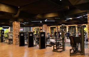 a gym with rows of exercise equipment in a room at Oxygym Hotel Faisalabad in Faisalabad
