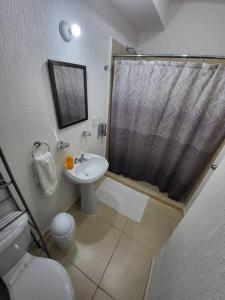 a bathroom with a toilet and a sink and a shower at Casa Espiral in Playa del Carmen