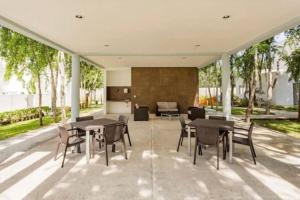 un patio avec tables et chaises dans un bâtiment dans l'établissement Casa Espiral, à Playa del Carmen