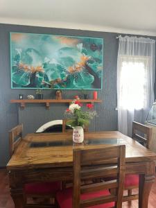 a dining room table with a painting on the wall at Hostal Gloria Viña in Viña del Mar