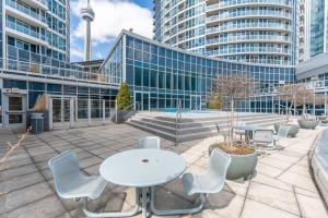 a patio with a white table and chairs and buildings at Toronto Views ~ Pool ~ BBQ ~ Harbourfront ~ WIFI in Toronto