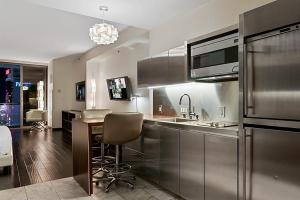 a kitchen with stainless steel appliances and a kitchen table at Palms Place Hotel Magnificent Suite w/ Strip View (open Balcony) in Las Vegas