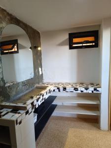 a bathroom with a sink and a mirror at Chez Arlette in Toubab Dialaw