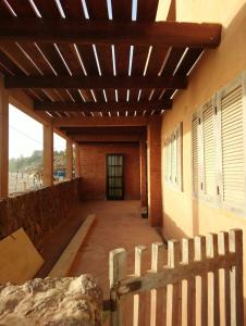 a porch of a building with a wooden ceiling at Chez Arlette in Toubab Dialaw