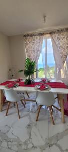 ein Esszimmer mit einem Tisch, Stühlen und einem Fenster in der Unterkunft Château Charles, Coubaril, stunning Ocean view a 12 min drive to Vigie Beach in Castries