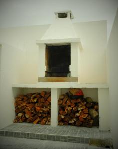 a pile of fire wood in a brick oven at Guest House De Fajã Ponta Delgada in Ponta Delgada
