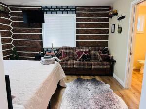 una camera da letto con un divano e una parete di tronchi di Two side-by-side apartments a Salem