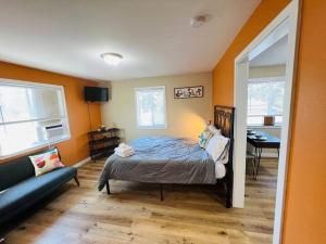 1 dormitorio con 1 cama y 1 sofá en Two side-by-side apartments en Salem