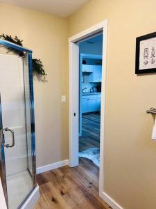 a bathroom with a shower and a door to a kitchen at Two side-by-side apartments in Salem