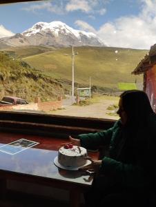 a woman sitting at a table with a cake at Chakana templo de montaña in Chimborazo