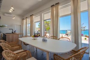 ein Esszimmer mit einem weißen Tisch und Stühlen in der Unterkunft Seaside house for families with children Mandre, Pag - 22604 in Kolan