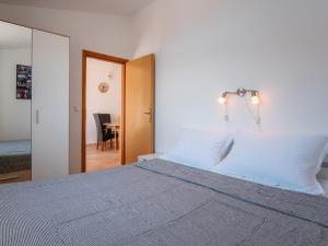 una camera da letto con un letto con lenzuola bianche e un tavolo di Apartments with parking space Pag - 22605 a Pag