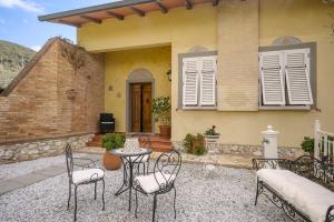 eine Terrasse mit Stühlen und einem Tisch vor einem Haus in der Unterkunft Villa Manuela in Luiano