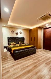 1 dormitorio con 1 cama grande en una habitación en British Hotel - Johar Town LHR en Lahore