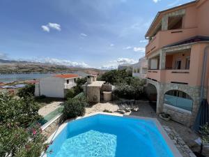 a swimming pool in front of a building at Apartments with swimming pool Pag - 22607 in Pag