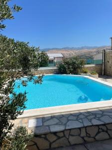 a large blue swimming pool in a yard at Apartments with swimming pool Pag - 22607 in Pag