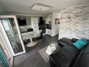 a living room with a black couch and a table at Apartments with swimming pool Pag - 22607 in Pag
