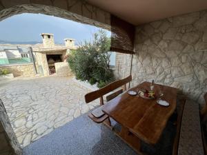 a wooden table and chairs sitting on a patio at Apartments with swimming pool Pag - 22607 in Pag
