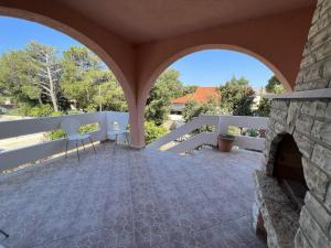 an outdoor patio with an archway and a fireplace at Holiday house with a parking space Simuni, Pag - 22608 in Kolan