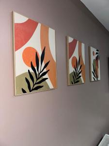 three pieces of art hanging on a wall at 1 Bedroom apartment With Hot Tub in cardiff in Cardiff