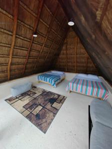 ein Zimmer mit 2 Betten und einem Sofa in einer Hütte in der Unterkunft El Cenote 11:11 in Tulum