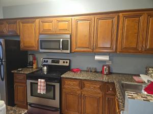 a kitchen with wooden cabinets and a stove and microwave at Sarah's Haven in Nassau