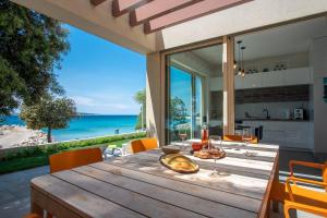 ein Esszimmer mit einem Tisch und Meerblick in der Unterkunft Seaside house for families with children Mandre, Pag - 22704 in Kolan