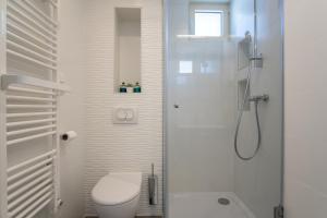 ein weißes Badezimmer mit Toilette und Dusche in der Unterkunft Seaside house for families with children Mandre, Pag - 22704 in Kolan