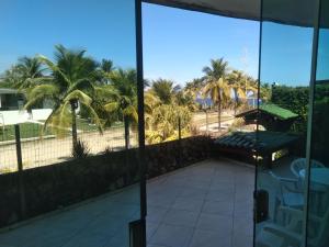 尼泰羅伊的住宿－Confortável, 1min da praia a pé，棕榈树房屋的阳台享有风景。