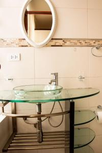 een badkamer met een glazen wastafel en een spiegel bij Departamento Familiar Equipado in Cuzco
