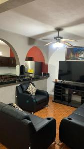 a living room with black furniture and a flat screen tv at Casa genesis in Panajachel