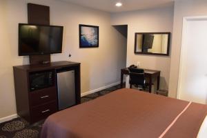 a hotel room with a bed and a flat screen tv at Country Inn in Santa Rosa