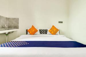 a bedroom with a bed with orange and blue pillows at OYO 78256 Hotal Kesariya in Rewāri