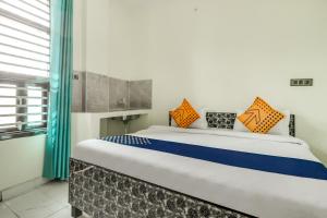 a bedroom with a large bed with orange and blue pillows at OYO 78256 Hotal Kesariya in Rewāri