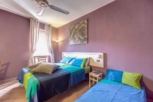 ローマにあるFrangipane Apartmentの紫の壁のドミトリールーム ベッド2台