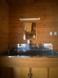 a bathroom with a large black sink and a mirror at Irori 新山ふるさと体験館 in Ina