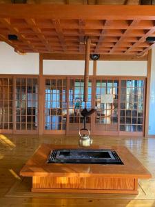 Irori 新山ふるさと体験館 في إينا: مطبخ مع طاولة مع غلاية في الأعلى