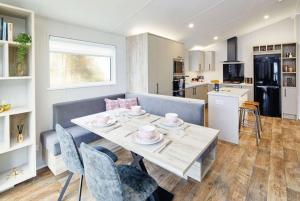 a dining room and kitchen with a table and chairs at Sandy Bay Lodge in Newbiggin-by-the-Sea