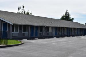 budynek z niebieskimi drzwiami i parkingiem w obiekcie Country Inn w mieście Santa Rosa