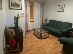 un salon avec un canapé vert et une télévision dans l'établissement Residencial Roxi, à Lisbonne
