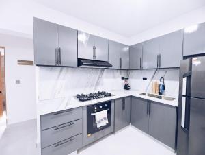a kitchen with white counters and stainless steel appliances at Apartment in Sosua - 4 Minutes From The Airport in San Felipe de Puerto Plata