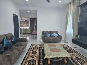 un soggiorno con due divani e una TV di Floria Desaru Homestay a Bandar Penawar