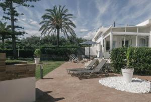 a house with a patio with chairs and a palm tree at Casa Vesalia a 1a línea de mar con AA y Wi-Fi. in Vinarós